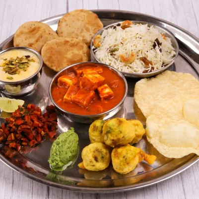 Vegetarian thali with paneer curry, puri, pulao and pakoras