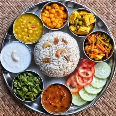 Thali with vegetable pulao, chana, beans, raita and salad