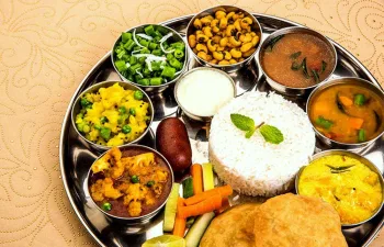 Vegetarian thali with rice, puri, matar, chana and seasonal sabzis